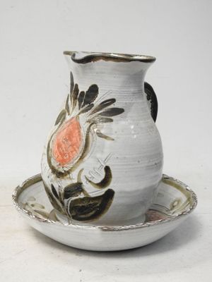 un vase blanc et une soucoupe ornés d'une fleur