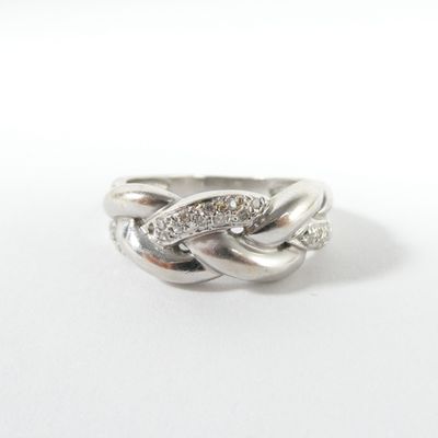 un gros plan d'une bague en argent sertie de diamants sur fond blanc