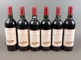six bouteilles de vin sont alignées sur une table