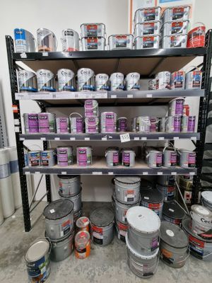 de nombreux seaux de peinture sur les étagères de la pièce