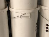 several white buckets stacked on top of each other in a room