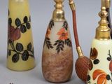 three different types of perfume bottles with tassels on them