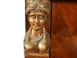 a gold statue of a woman on top of a wooden cabinet