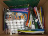 a cardboard box filled with assorted school supplies