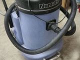 un aspirateur posé sur le sol de la pièce
