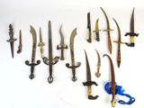 a lot of knives that are hanging on the wall