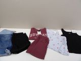 several pairs of shorts and t - shirts laid out on a table