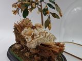 a figurine of a baby in a cradle under a tree