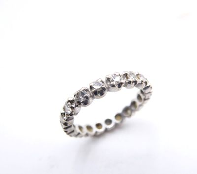 a close up of a diamond ring on a white surface