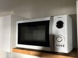 a microwave that is on a shelf in a kitchen