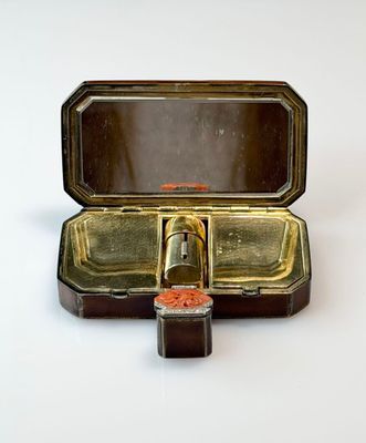 a small metal box with a small red object inside of it