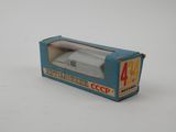 a small toy car in a box on a white surface