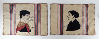 two embroidered portraits of a man and a woman on a wall