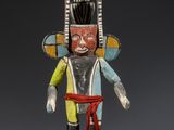 une image représentant une statue en bois d'un homme portant une ceinture rouge