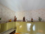 il y a de nombreux vases accrochés au mur dans cette pièce