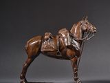 bronze statue of a horse with a saddle on a wooden base