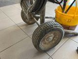 a yellow bucket sitting on the floor next to a wheel