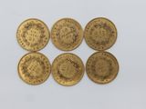 six pièces d'or sur lesquelles figurent l'effigie d'un homme et d'une femme