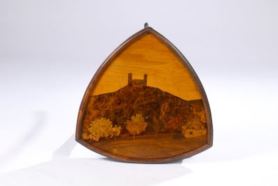 un objet en bois de forme triangulaire sur lequel est représenté un château