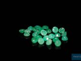 a close up of a bunch of green gems on a black surface