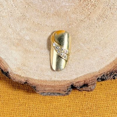 une bague en or sertie d'un diamant, posée sur un morceau de bois