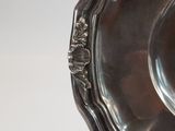 a silver plate with a decorative design on it