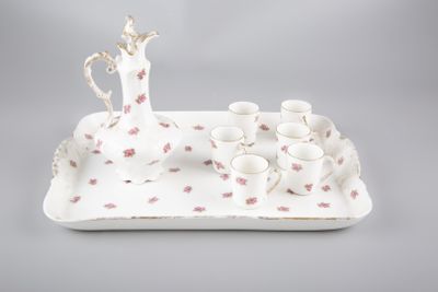 une image représentant un plateau blanc orné de fleurs roses