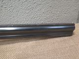 a close up of a gun on a table with a wall in the background