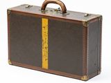 an old suitcase with a yellow stripe on the side