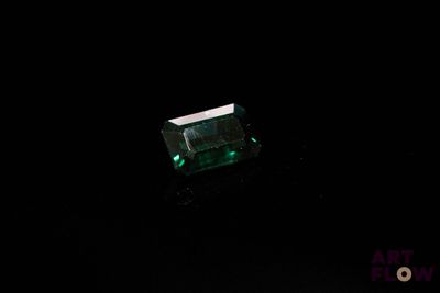 un gros plan d'une émeraude verte sur une surface noire