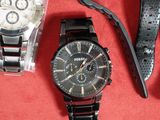 trois montres et un bracelet de montre posés sur une surface rouge