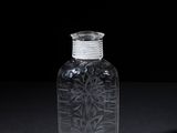 clear glass bottle on a black surface with a black background