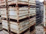 many metal crates stacked up in the dirt