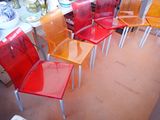 many different colored chairs lined up in a room
