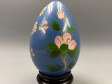 an image of a blue egg with flowers painted on it
