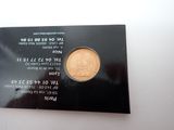 an image of a gold coin on a black card on a white surface