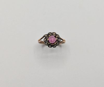 une bague en or sertie d'une pierre rose entourée de diamants noirs