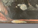 a black table with a painting on the top of it