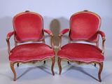 paire de fauteuils recouverts de velours rouge, avec des accoudoirs en bois sculpté