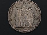 a silver coin with a picture of a man and a woman on it