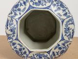 a blue and white vase sitting on top of a table