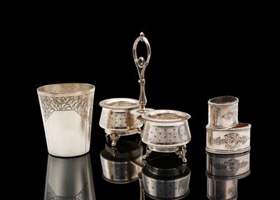 a silver cup and other silver objects on a black surface