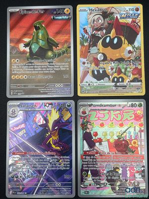 Quatre cartes Pokémon différentes sont posées sur une table.