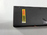 a black cell phone with a yellow sticker on it