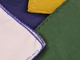 trois serviettes de table de couleurs différentes, ornées d'un logo