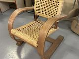 une chaise en bois et en osier posée à même le sol