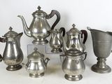 beaucoup de cafetières et de pichets en argent sur la table