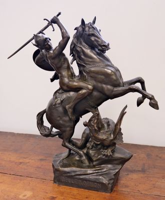 statue of a man on a horse with a sword on a wooden table