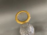a small glass bottle with a yellow ring on it