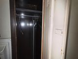 un placard dans un coin d'une pièce, dont la porte est ouverte
